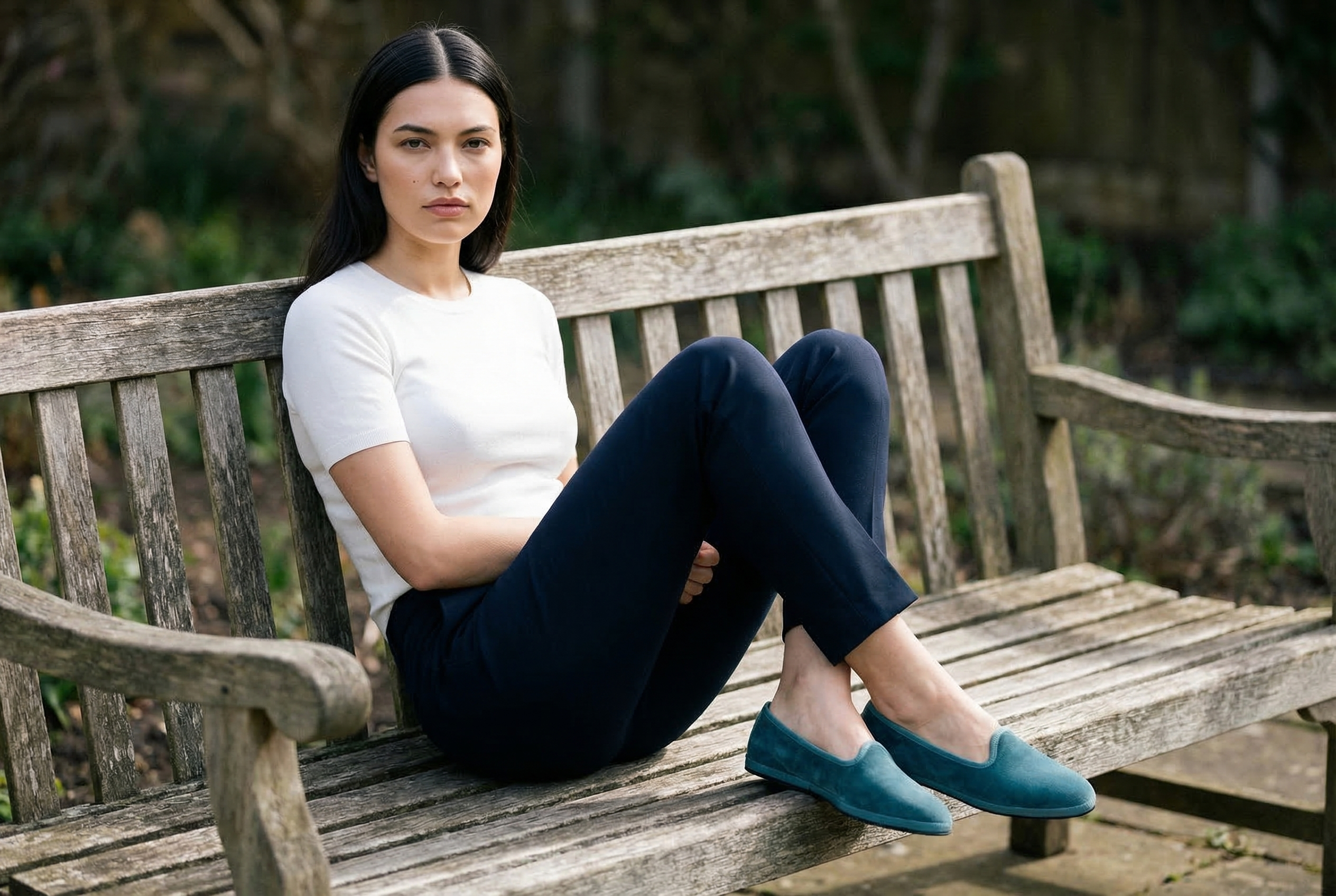 Modella seduta su panchina con Friulane Babine in velluto verde fiordo, outfit navy, fatte a mano in Friuli – Le Babine